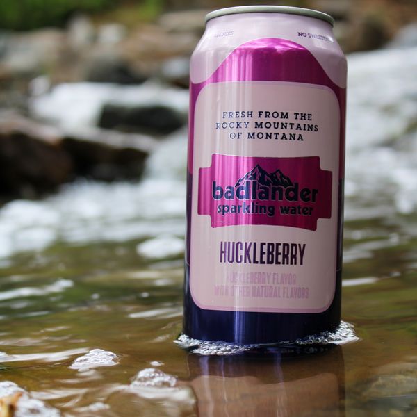 Can of Badlander Huckleberry Seltzer Water in a calm stream of water.